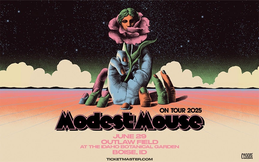 A psychedelic-style poster for Modest Mouse's 2025 tour features a surreal illustration of large, cracked hands emerging from the ground, with one holding a rose that has a classical statue-like face in its petals. The background depicts a starry night sky with clouds and a colorful, dreamlike landscape. The band’s name, &quot;Modest Mouse,&quot; is displayed in bold, stylized text, and concert details for June 29 at Outlaw Field in Boise, Idaho, are listed below. The Ticketmaster logo and &quot;C Moore Concerts&quot; branding appear at the bottom.