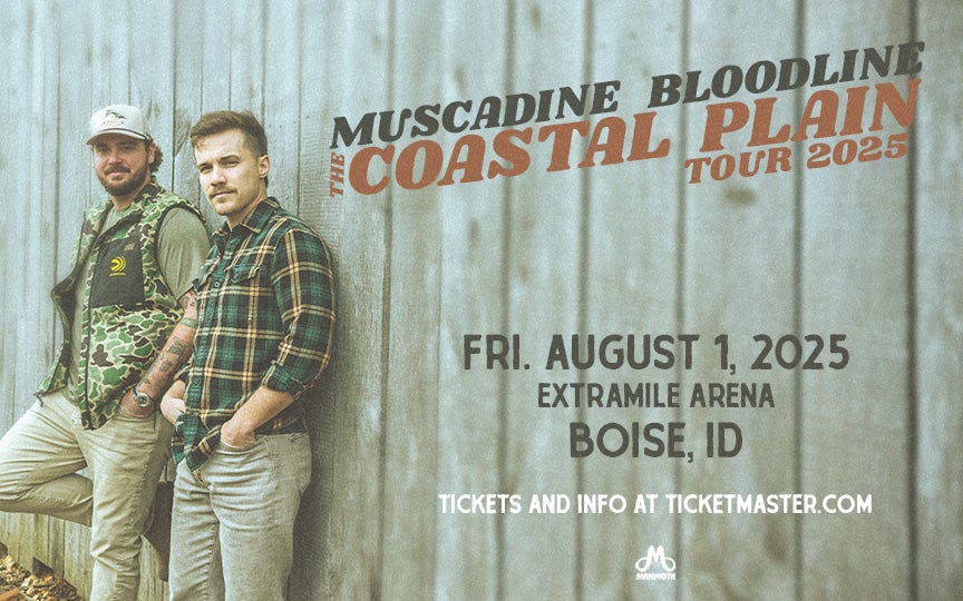 A promotional image for Muscadine Bloodline's Coastal Plain Tour 2025. Two band members stand against a rustic wooden wall, dressed in casual country attire—one wearing a camouflage vest and cap, the other in a plaid shirt and boots. The text announces their concert on Friday, August 1, 2025, at ExtraMile Arena in Boise, ID, with ticket information available at Ticketmaster.com. The image has a vintage, muted color tone, with bold typography highlighting the tour name.